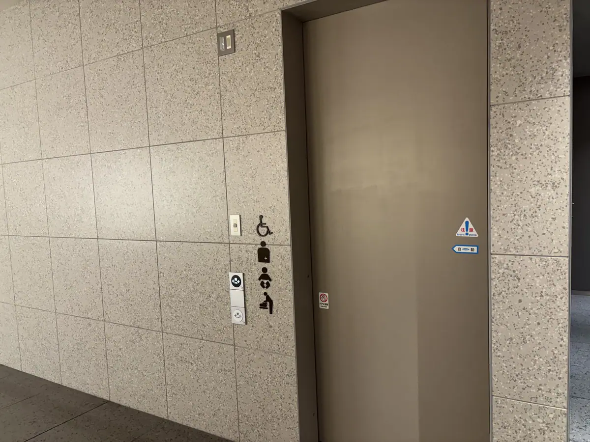 Entrance to a multipurpose restroom at Tokyo Midtown Yaesu with wheelchair and baby-care symbols